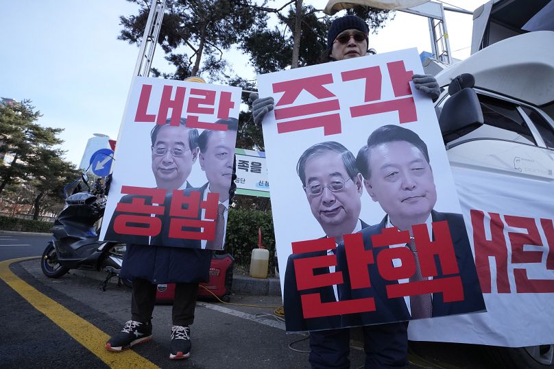 Des manifestants brandissent des images du président Yoon Suk Yeol, à droite, et du président par intérim Han Duck-soo, à Séoul, en Corée du Sud, le 27 décembre 2024.