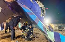 In this photo released by Kazakhstan's Emergency Ministry Press Service, rescuers work at the wreckage of Azerbaijan Airlines Embraer 190 lies on the ground near the airport.