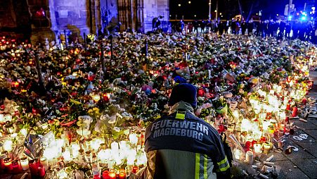 Fiori deposti davanti alla chiesa di Johannis, vicino al mercatino di Natale di Magdeburgo, Germania, lunedì 23 dicembre 2024.