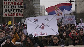 People stopping traffic, stand in silence during ongoing protests that erupted after a concrete canopy fell last month and killed 15 people in front of a government building