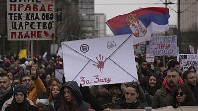 People stopping traffic, stand in silence during ongoing protests that erupted after a concrete canopy fell last month and killed 15 people in front of a government building