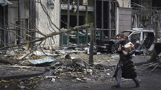 Una donna passa davanti agli edifici distrutti dai recenti attacchi russi a Kiev, 20 dicembre 2024