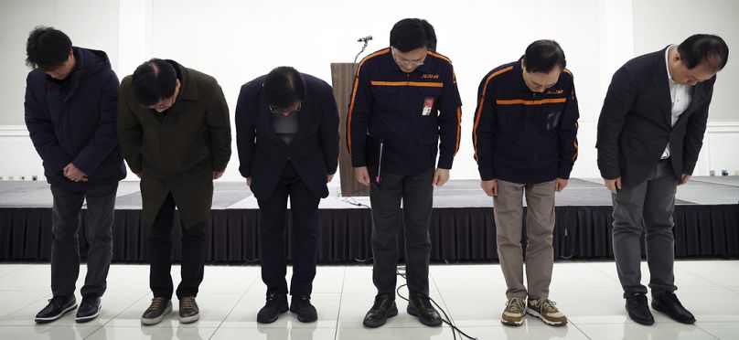 Jeju Air CEO Kim E-bae, fourth from left, and other executive members bow in apology ahead of a briefing in Seoul, South Korea, Sunday, Dec. 29, 2024