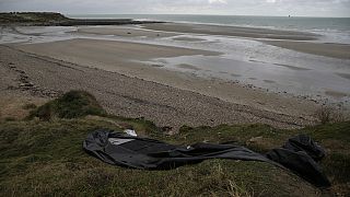 FILE - A damaged inflatable small boat is pictured on the shore in Wimereux, northern France, on Nov. 25, 2021 in Calais, northern France.