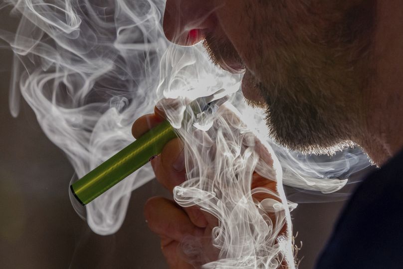 Un homme utilise une cigarette électronique jetable