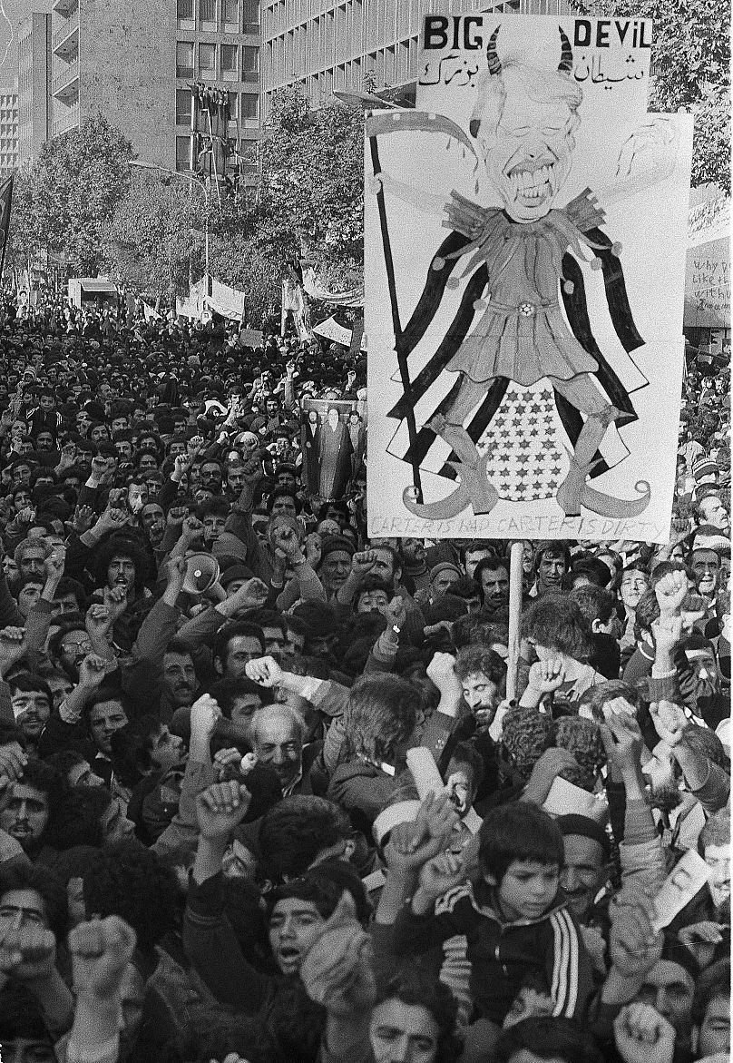 کاریکاتور جیمی کارتر در دستان تظاهرکنندگان در برابر سفارت آمریکا در تهران