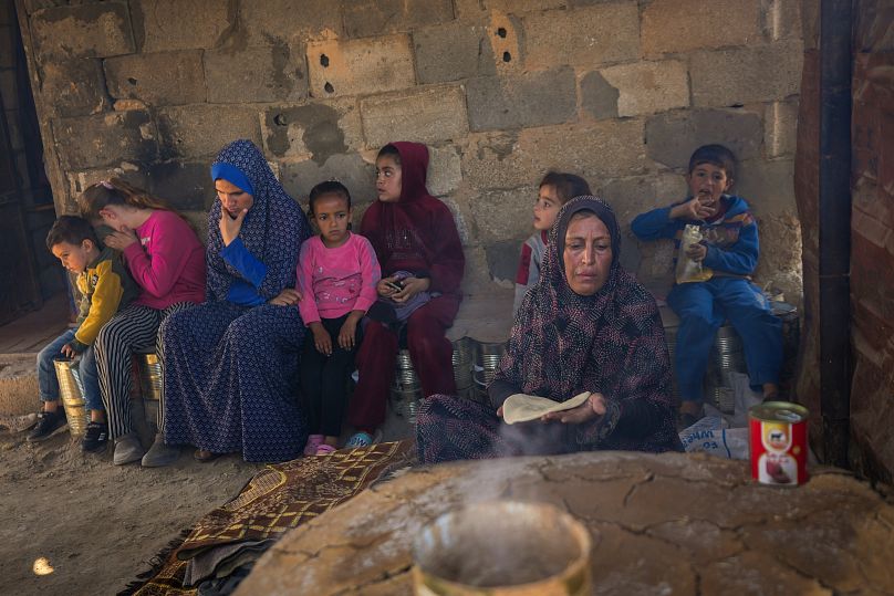 أمل الجالي، 46 عامًا، أم لـ 14 نازحًا من مدينة غزة، تعدّ الخبز في مخيم للنازحين الفلسطينيين في دير البلح بقطاع غزة، في 7 نوفمبر/تشرين الثاني 2024