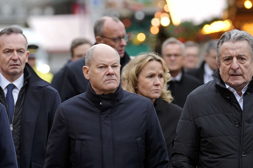 Kanclerz Niemiec Olaf Scholz (środek) odwiedza jarmark bożonarodzeniowy, na którym samochód wjechał w tłum, 21 grudnia 2024