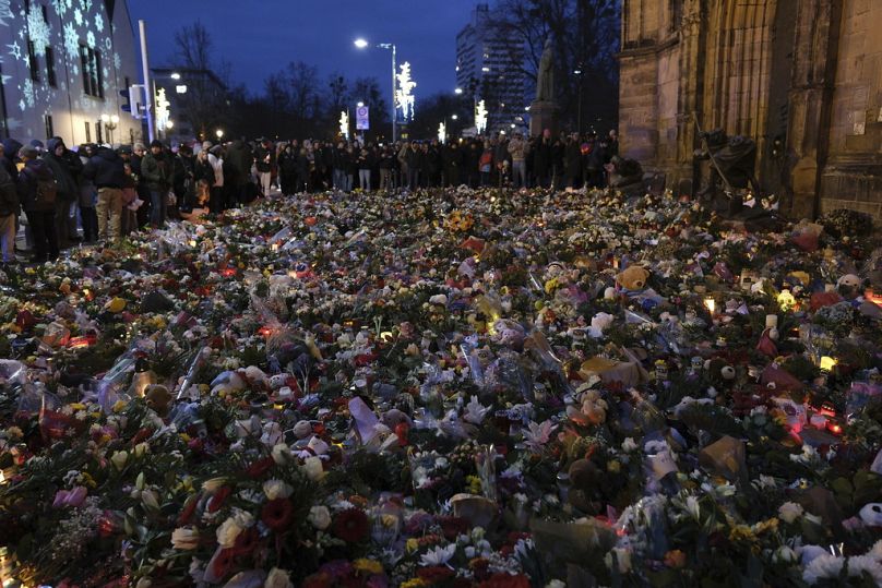 Kwiaty, świece i duże ofiary żałobne przed kościołem św. Jana, w pobliżu jarmarku bożonarodzeniowego, gdzie samochód wjechał w tłum, Magdeburg 23.12.2024