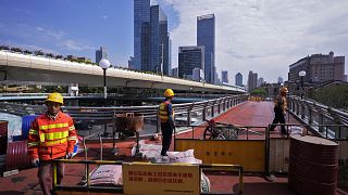 Workers in Shanghai constructing an overhead pedestrian bridge 