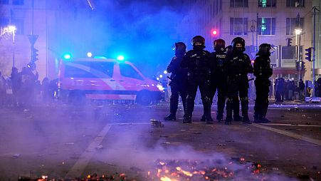 Police officers stand guard in the streets after fireworks for the New Year's celebrations in Berlin, Germany, Wednesday, Jan. 1, 2025. 