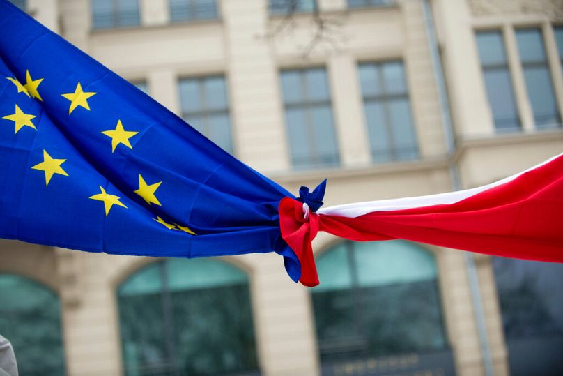 Polish and EU flags knotted together. 