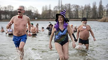 أشخاص يرتدون القبعات والقبعات الفاخرة يحضرون السباحة السنوية للعام الجديد لنادي السباحة الشتوي ”سيهوندي برلين“، في يوم رأس السنة في بحيرة أورانكه في برلين، ألمانيا،