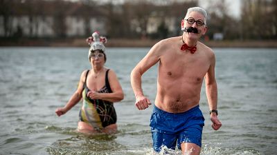 People with fancy hats and caps attend the annual New Year swim with the winter swimming club 'Seehunde Berlin', on New Year's Day at the Oranke Lake in Berlin Jan. 1, 2025.