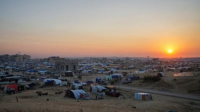 The sun sets over a tent camp for displaced Palestinians in the central Gaza Strip town of Khan Younis, Wednesday, Jan. 1, 2025.