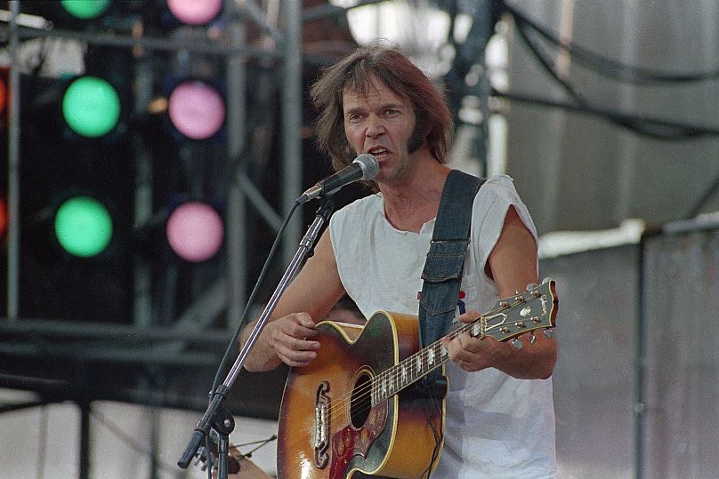 Neil Young, playing a Gibson J-200 acoustic guitar, performs during the Live Aid concert for famine relief at JFK Stadium in Philadelphia, Pa. July 13, 1985.