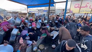 Crowds wave pots overhead in scramble to get food aid in Khan Younis