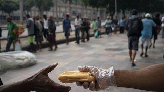 Homeless people gather for coffee and bread in Rio de Janeiro, Brazil, in March 2020.