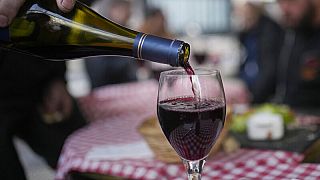 FILE: A customer pours a glass of Beaujolais Nouveau wine in a restaurant of Boulogne Billancourt, outside Paris, Thursday, Nov. 18, 2021. 