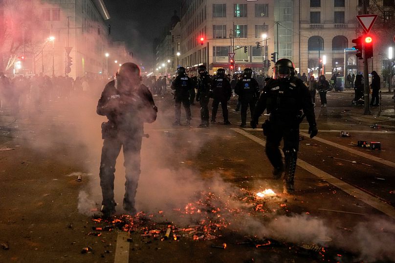 ضباط الشرطة يطفئون النيران في الشوارع بعد الألعاب النارية في احتفالات رأس السنة الجديدة في برلين، ألمانيا، الأربعاء، 1 يناير/كانون الثاني 2025