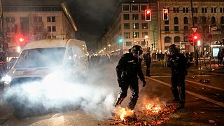 Agenti di polizia spengono il fuoco nelle strade dopo i fuochi d'artificio per i festeggiamenti di Capodanno a Berlino, Germania, mercoledì 1 gennaio 2025.