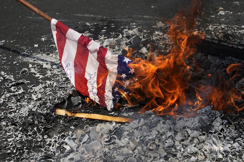 Manifestantes queman una bandera estadounidense durante su concentración anual en conmemoración de la Revolución Islámica de Irán de 1979 en Teherán, 11 de febrero de 2024.