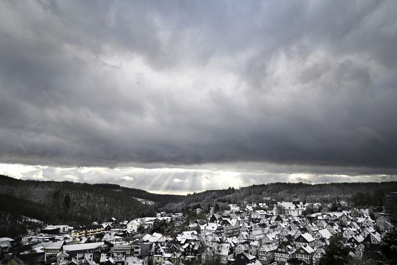 Snow falls on the roofs of the half-timbered houses in the historic city center in Freudenberg, Germany, Friday, Jan. 3, 2025. (Federico Gambarini/dpa via AP)