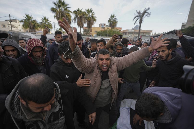 فلسطينيون يشيعون أقاربهم الذين قتلوا في القصف الإسرائيلي على قطاع غزة، في مستشفى شهداء الأقصى في دير البلح، الأحد، 5 يناير/كانون الثاني 2025
