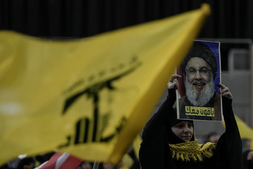 لبناني يرفع صورة حسن نصر الله كتب عليها بالعربية: "سنبقى معكم"، خلال تجمع حاشد لإحياء يوم القدس، في الضاحية الجنوبية لبيروت 5 أبريل 2024