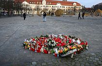 Flowers and candles are seen on a place of remembrance for the victims of the attack at Christmas market on the cathedral square with the Saxony-Anhalt parliament building. 