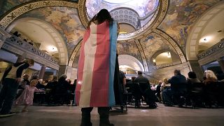 A young person wears a transgender flag in March 2023 at a political event in Missouri, United States.