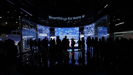 People look at a display of Samsung screens and products at the CES tech show Tuesday, January 7, 2025, in Las Vegas.