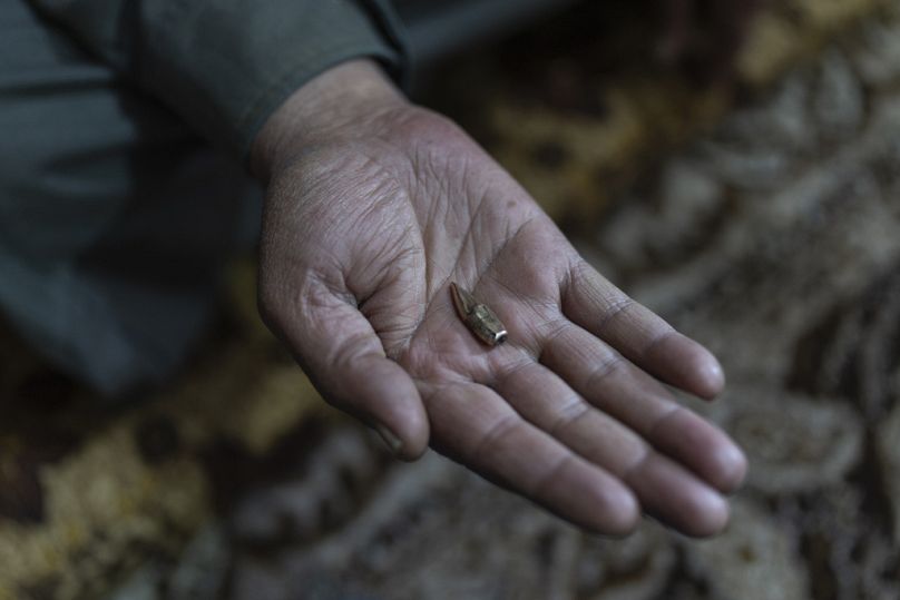 رجل يحمل رصاصة استُخرجت من بطن ابنه الذي أصيب خلال احتجاج ضد توغل الجيش الإسرائيلي في قريتهم السويسة، قرب القنيطرة، سوريا، الأحد 5 يناير 2025. 