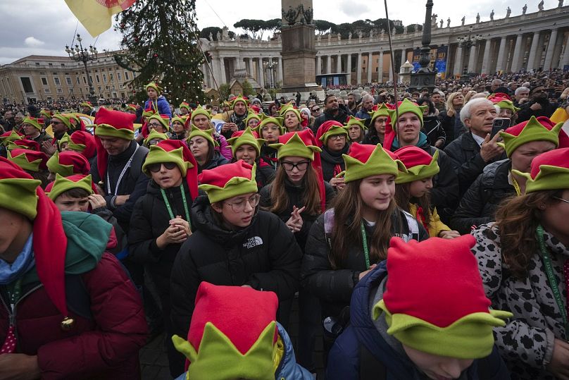 Niños rezan durante la oración del Ángelus dirigida por el Papa Francisco con motivo del día de la Epifanía, desde la ventana de su estudio con vistas a la Plaza de San Pedro.