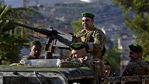 FILE - Lebanese army soldiers sit on their armored vehicle as they patrol the Lebanese side of the Lebanese-Israeli border in the southern village of Kfar Kila, Lebanon,