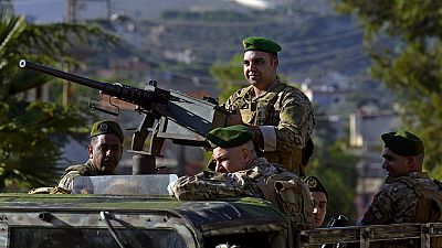 FILE - Lebanese army soldiers sit on their armored vehicle as they patrol the Lebanese side of the Lebanese-Israeli border in the southern village of Kfar Kila, Lebanon,