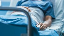 Ein Patient liegt in einem Krankenhausbett.