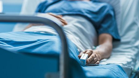 A patient lies in a hospital bed.