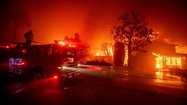 I vigili del fuoco combattono l'incendio di Palisades mentre brucia diverse strutture nel quartiere di Pacific Palisades a Los Angeles, 7 gennaio 2025