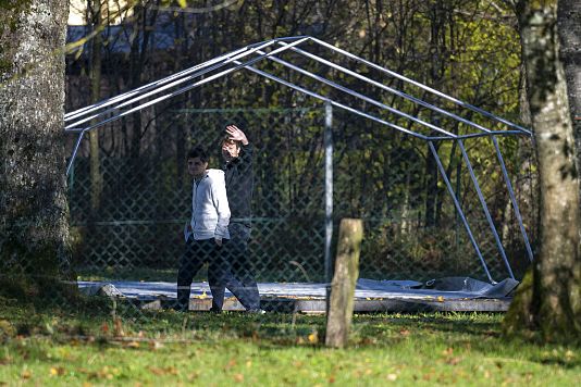 Dwaj mężczyźni przechodzą obok stelażu namiotu, który miał posłużyć jako tymczasowe schronienie dla uchodźców w Sankt Georgen im Attergau, w Austrii.