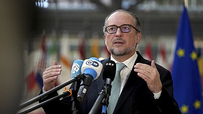 Austria's Foreign Minister Alexander Schallenberg speaks with the media as he arrives for a meeting of EU foreign ministers at the European Council building in Brussels, Monda