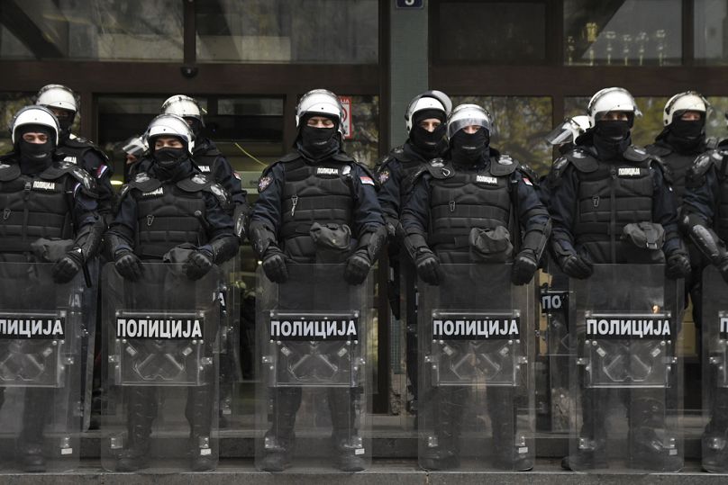 Agentes da polícia sérvia guardam um tribunal durante um protesto antigovernamental que exigia prisões por causa de um desabamento mortal de um telhado na estação ferroviária