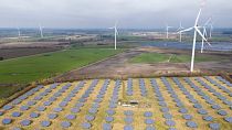 Paneles solares al borde de un parque eólico en Sprakebuell, Alemania.