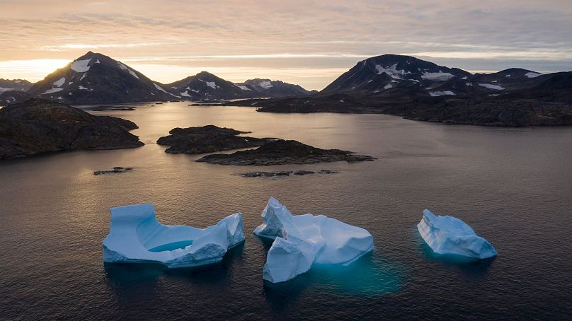  Large icebergs float away as the sun rises near Kulusuk, Greenland, August 2019.