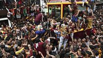 During its annual procession in Manila, Philippines, the faithful climb onto the cart carrying the statue of Jesus Nazareno, 09.01.2025