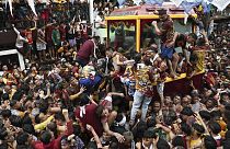 During its annual procession in Manila, Philippines, the faithful climb onto the cart carrying the statue of Jesus Nazareno, 09.01.2025