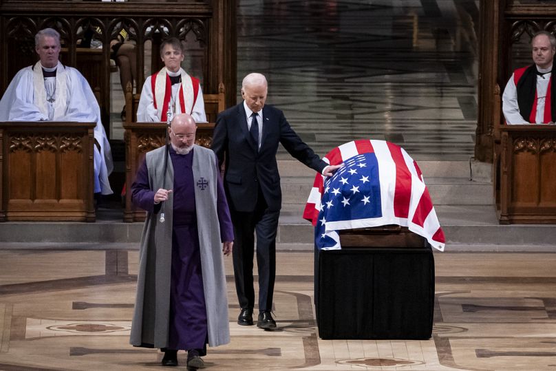 Joe Biden berührt den in die amerikanische Flagge gehüllten Sarg von Carter