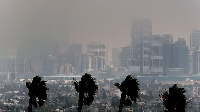 High winds blow as thick smoke from wildfires shrouds downtown Los Angeles on Wednesday, Jan. 8, 2025. 