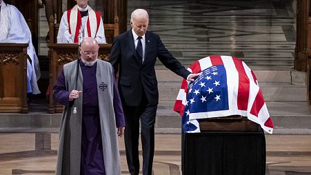 President Joe Biden touches the casket of former President Jimmy Carter after delivering remarks during Carter's state funeral at the National Cathedral, Thursday, Jan 9, 2025