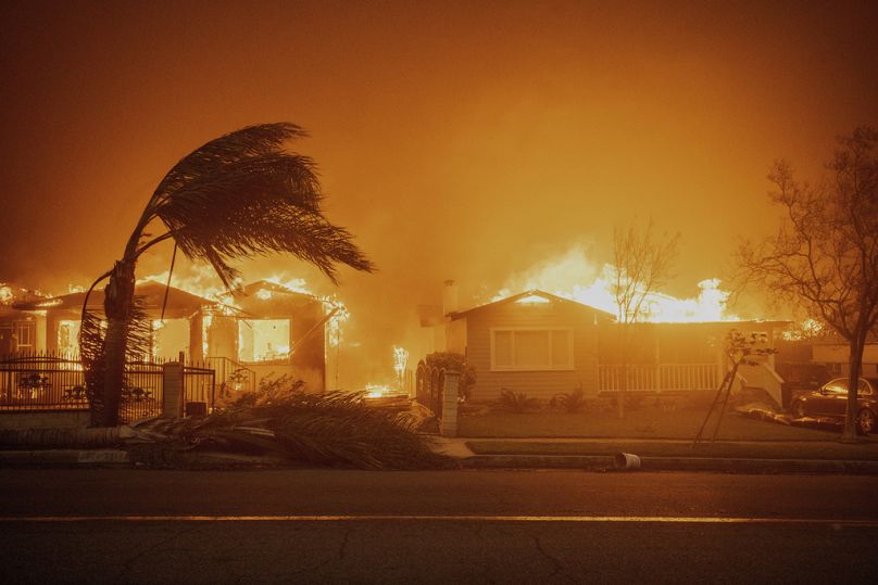 Bäume schwanken bei starkem Wind, während das Eaton-Feuer am Mittwoch, 8. Januar 2025, in Altadena, Kalifornien, Gebäude abbrennt. 